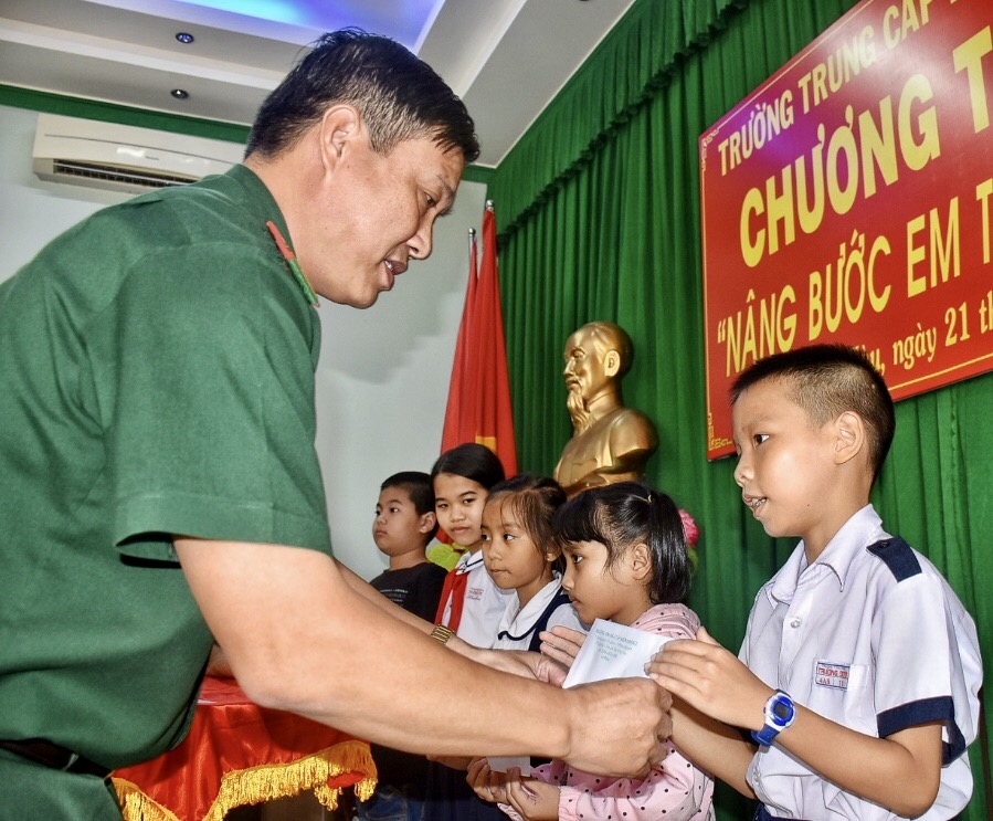 Đại tá Nguyễn Xuân Toàn, Chính uỷ Trường Trung cấp Biên phòng 2 trao học bổng cho các em HS trong chương trình “Nâng bước em tới trường”.