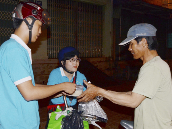 Tình nguyện viên của Đội tình nguyện BVU phát cháo, nước uống cho người nghèo trên đường 2-9, TP.Vũng Tàu.