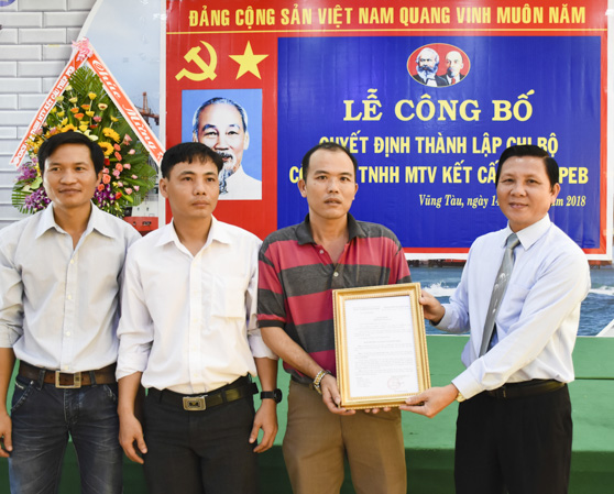 Đồng chí Mai Minh Quang (bìa phải), Bí thư Đảng ủy Khối Doanh nghiệp tỉnh trao quyết định thành lập Chi bộ cơ sở Công ty TNHH MTV kết cấu thép PEB. Ảnh: ĐÔNG TRÚC