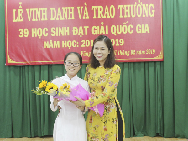 Cô Lữ Thị Trà Giang, Hiệu trưởng Trường THPT Chuyên Lê Quý Đôn tặng hoa chúc mừng em Ngô Trần Anh Thư, đại diện cho 39 HS đoạt giải của tỉnh BR-VT. 