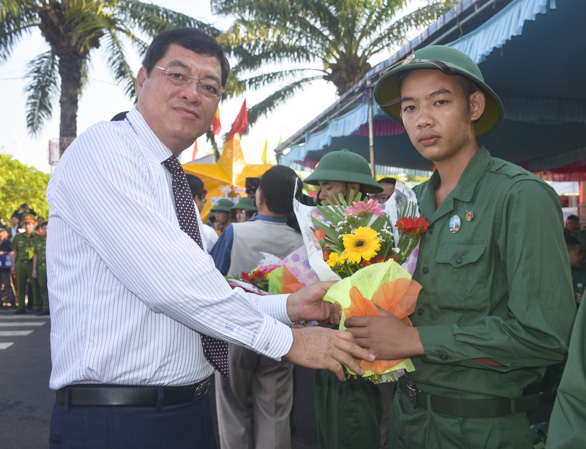 Đồng chí Trần Đình Khoa, Phó Chủ tịch HĐND tỉnh tặng hoa cho tân binh. Ảnh: VĂN ANH