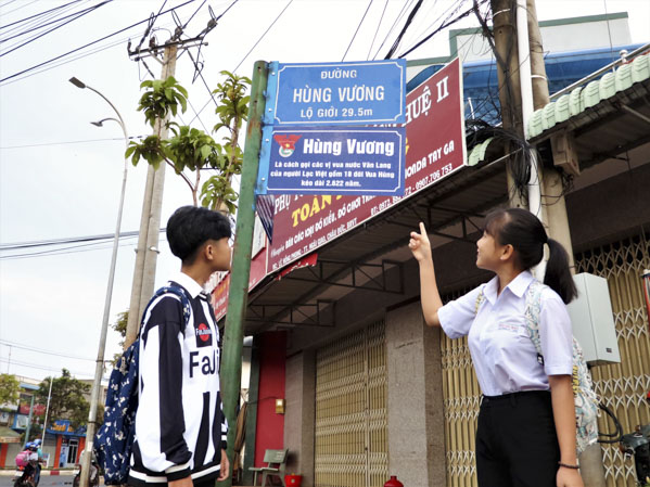 HS Trường THPT Nguyễn Trãi thích thú khi xem bảng chú thích các nhân vật lịch sử (Lê Hồng Phong - Hùng Vương) tại TT. Ngãi Giao.