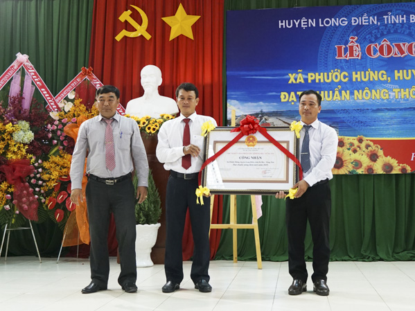 Đại diện UBND xã Phước Hưng đón nhận quyết định xã đạt chuẩn NTM của UBND tỉnh.