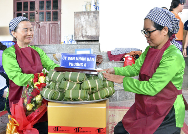 Thí sinh Hoàng Thị Nguyên (trái) và Nguyễn Thị Hoa, đội phường 8 trang trí mâm bánh chưng để Ban giám khảo chấm điểm sau khi hoàn thành xong phần thi.