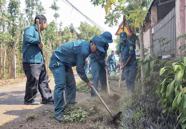 Cán bộ, chiến sĩ Ban CHQS huyện Châu Đức làm vệ sinh môi trường tại thôn 1, xã Bình Trung.   