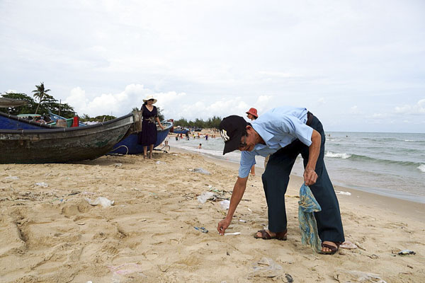 Một du khách nhặt rác trên bãi biển Phước Thuận (huyện Xuyên Mộc) chiều 28-4.