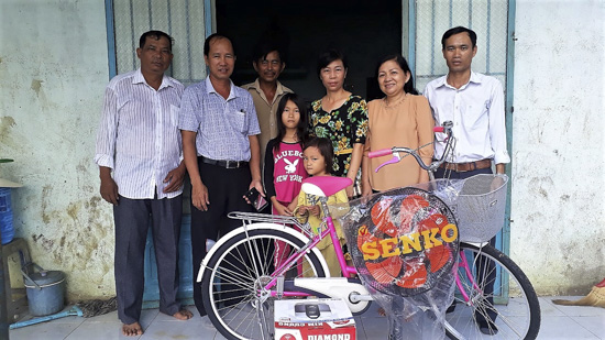 Gia đình ông Nguyễn Văn Hùng (đứng giữa), ở ấp Bàu Hàm, xã Tân Lâm, huyện Xuyên Mộc rất vui được nhận quà và chiếc xe đạp, phương tiện cần thiết cho con đi học mỗi ngày.