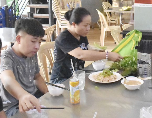 Gia đình chị Nguyễn Thị Ba (TP. Biên Hòa, Đồng Nai) thưởng thức gỏi cá mai tại quán Vườn Xoài.