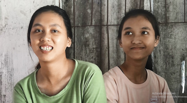 Nụ cười luôn nở trên khuôn mặt ngây thơ của 2 cô gái Nguyễn Thị Trinh  (bìa trái) và Nguyễn Thị Tuyết Hương khuyết tật.