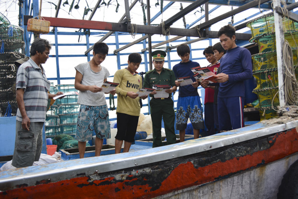 Lực lượng BĐBP phát tờ rơi tuyên truyền pháp luật cho ngư dân.