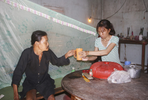 Chị Nguyễn Ngọc Tuyền chăm sóc người cha bị bệnh, phải ngồi một chỗ. 