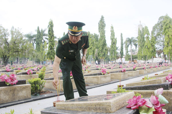 Lực lượng vũ trang tỉnh thắp nhang trên các phần mộ liệt sĩ.