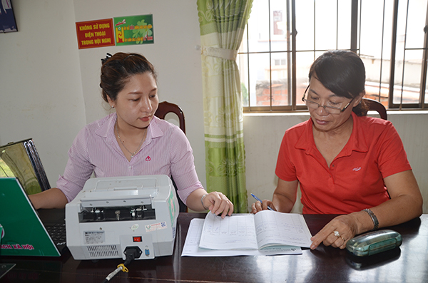 Chị Trần Thị Toàn (bìa phải, buôn bán ở chợ Vũng Tàu) làm thủ tục nhận khoản vay ưu đãi 40 triệu đồng chương trình giải quyết việc làm từ nguồn vốn do ngân sách địa phương chuyển sang NHCSXH.