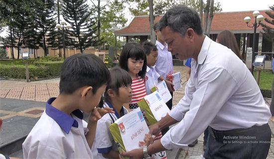 Ông Lê Manh Tân, Phó Bí thư Đảng ủy xã Bình Ba trao sách giáo khoa cho học sinh có hoàn cảnh khó khăn trên địa bàn xã.