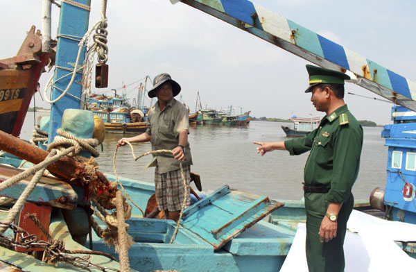 Lực lượng biên phòng tuyên truyền cho ngư dân về vùng đánh bắt hợp pháp.  Ảnh: QUANG VINH