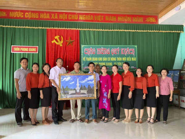 Ông Nguyễn Tấn Bản, Phó Chủ tịch UBND huyện Châu Đức tặng bức tranh Tượng đài Chiến thắng Bình Giã cho cán bộ, chị em phụ nữ thôn Phong Giang, xã Tiên Điền, huyện Nghi Xuân, tỉnh Hà Tĩnh.