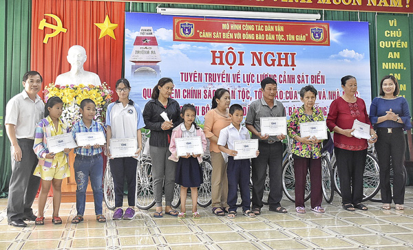 Ông Nguyễn Văn Thắng, Phó Trưởng Ban Tuyên giáo Tỉnh ủy (bìa trái) trao học bổng cho HS nghèo hiếu học.