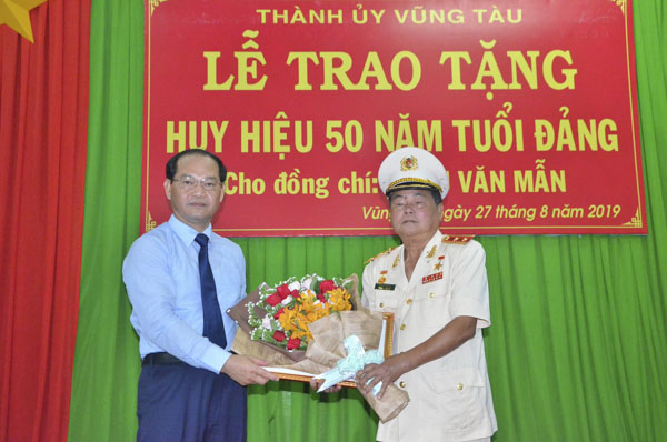 Ông Mai Ngọc Thuận, Ủy viên Ban Thường vụ Tỉnh ủy, Bí thư Thành ủy Vũng Tàu trao huy hiệu 50 tuổi Đảng cho Trung tướng, Anh hùng LLVTND Châu Văn Mẫn. 