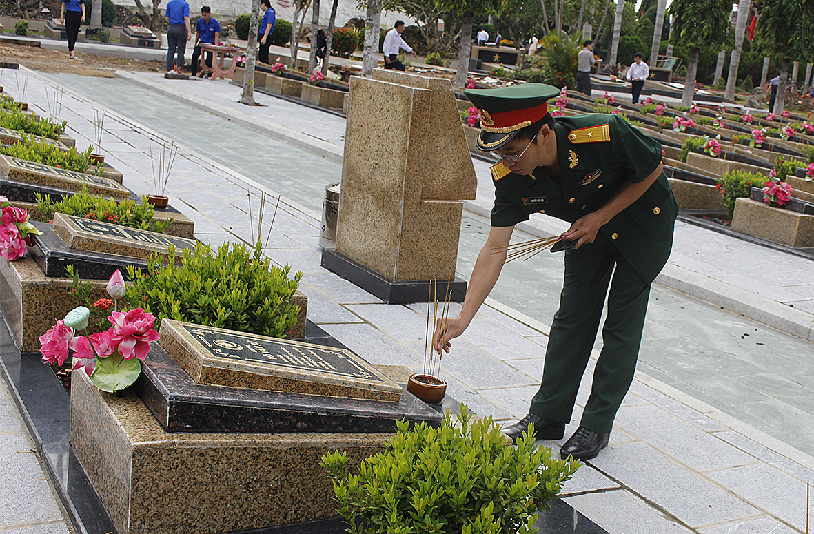 Đại diện lực lượng vũ trang tỉnh thắp nhang tại các phần mộ liệt sĩ.