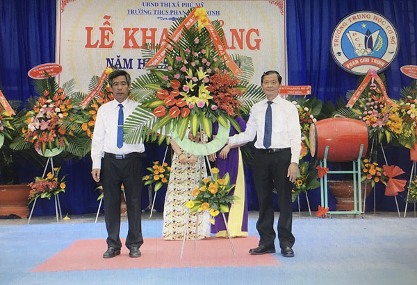 Ông Lương Trí Tiên, Ủy viên Ban Thường vụ Tỉnh ủy, Trưởng Ban Nội chính Tỉnh ủy (bìa phải) tặng hoa chúc mừng trong Lễ Khai giảng của Trường THCS Phan Chu Trinh (TX. Phú Mỹ).