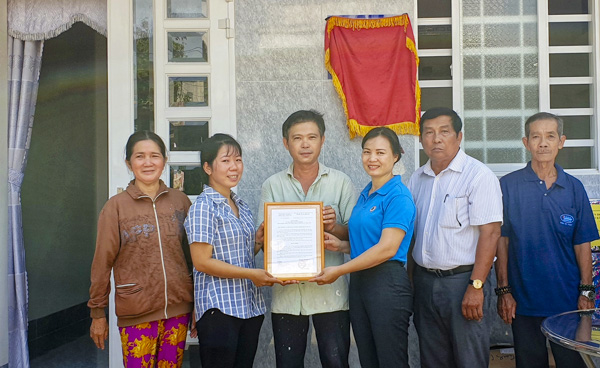 Bà Huỳnh Thị Phúc (thứ 3, từ phải qua), Phó Chủ tịch LĐLĐ tỉnh trao Quyết định bàn giao nhà cho gia đình chị Nguyễn Thanh Trúc.