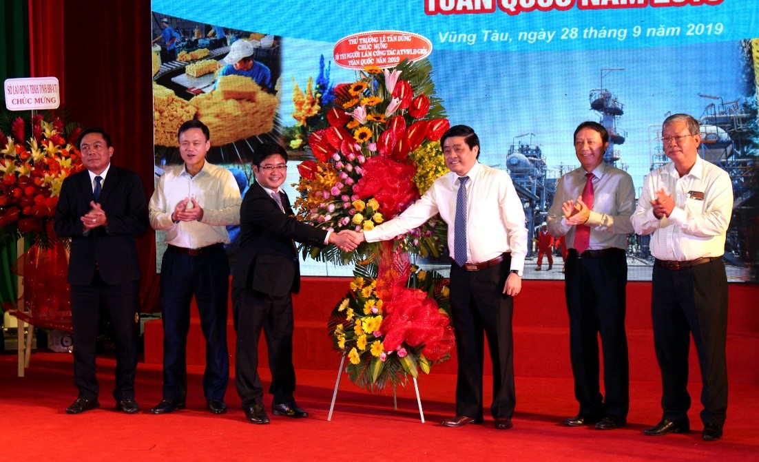 Ông Hà Tất Thắng (bên phải), Cục trưởng Cục An toàn lao động (Bộ LĐ-TB-XH) tặng hoa chúc mừng hội thi.