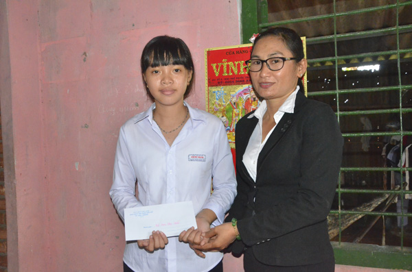 Bà Bùi Thị Kim Thủy, Chủ tịch Hội LHPN thị trấn Đất Đỏ trao học bổng Nguyễn Thị Định cho em Nguyễn Thị Kim Quyên.