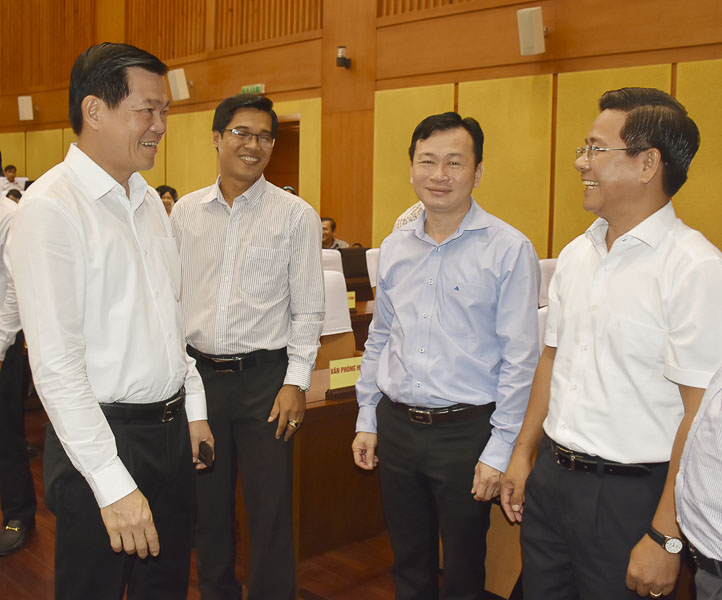 Ông Nguyễn Hồng Lĩnh, Ủy viên Trung ương Đảng, Bí thư Tỉnh ủy, Chủ tịch HĐND tỉnh (bên trái) trao đổi với các đại biểu bên lề hội nghị.
