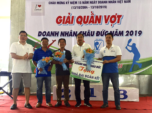 Ông Trần Quốc Minh, Giám đốc Công ty hạt điều Phúc Vinh (ngoài cùng bên phải) trao biểu trưng nhà Đại đoàn kết cho đại diện lãnh đạo huyện Châu Đức.