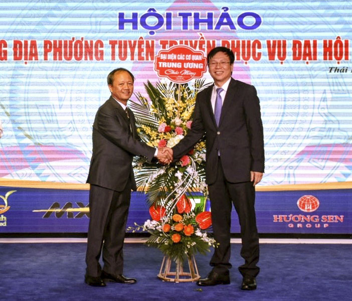 Nhà báo Hồ Quang Lợi, Phó Chủ tịch Thường trực Hội Nhà báo Việt Nam (bên phải) tặng hoa chúc mừng hội thảo.