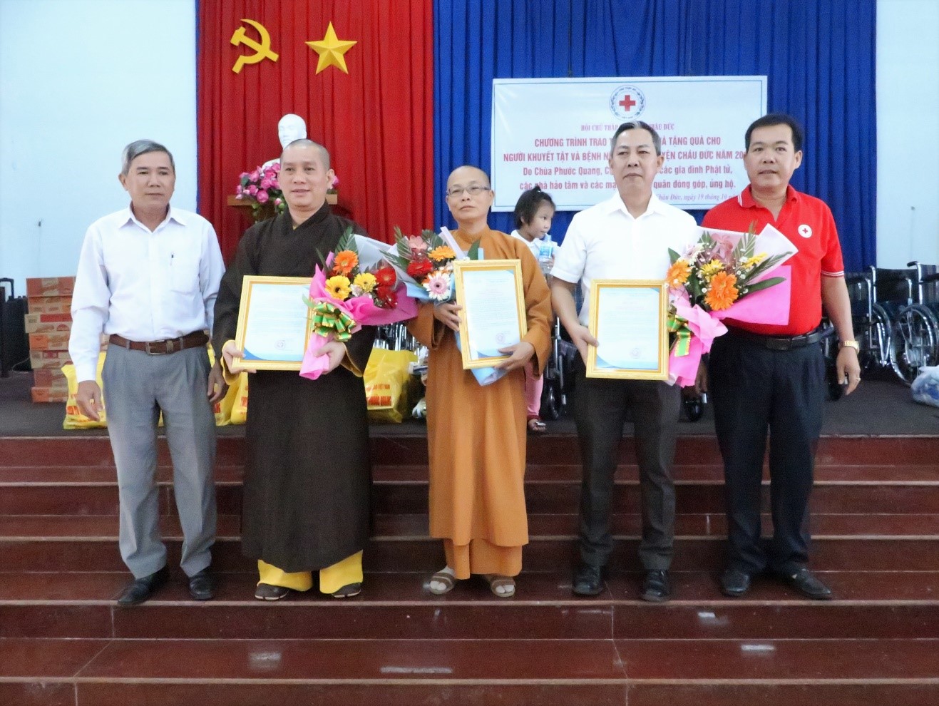 Ông Trần Văn Đức (bìa trái), Trưởng Phòng LĐTB-XH huyện và ông Nguyễn Thành Tài (bìa phải), Chủ tịch Hội CTĐ huyện trao thư cảm ơn cho các nhà tài trợ.