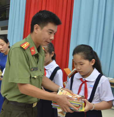 Thiếu tá Đặng Thanh Tuấn, Bí thư Đoàn Công an tỉnh tặng sách cho HS Trường TH Phước Thắng.