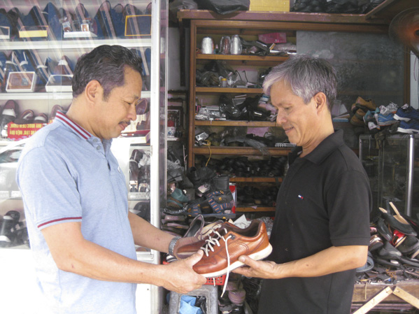 Ông Phạm Thanh Nhân (bên phải) giới thiệu sản phẩm cho khách.
