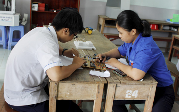 Em Phạm Thị Thùy Trang (bên phải) đến trường để nghiên cứu ý tưởng thiết kế bảng chữ cái dành cho HS khiếm thị.