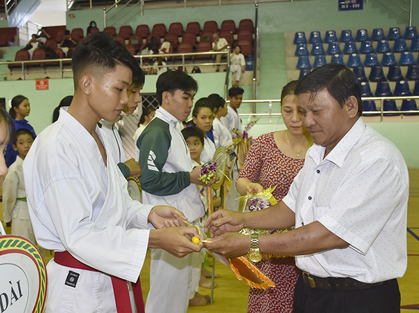 Ông Đặng Văn Cường, Giám đốc Trung tâm HL-TĐ TDTT tỉnh tặng cờ lưu niệm cho các đơn vị.