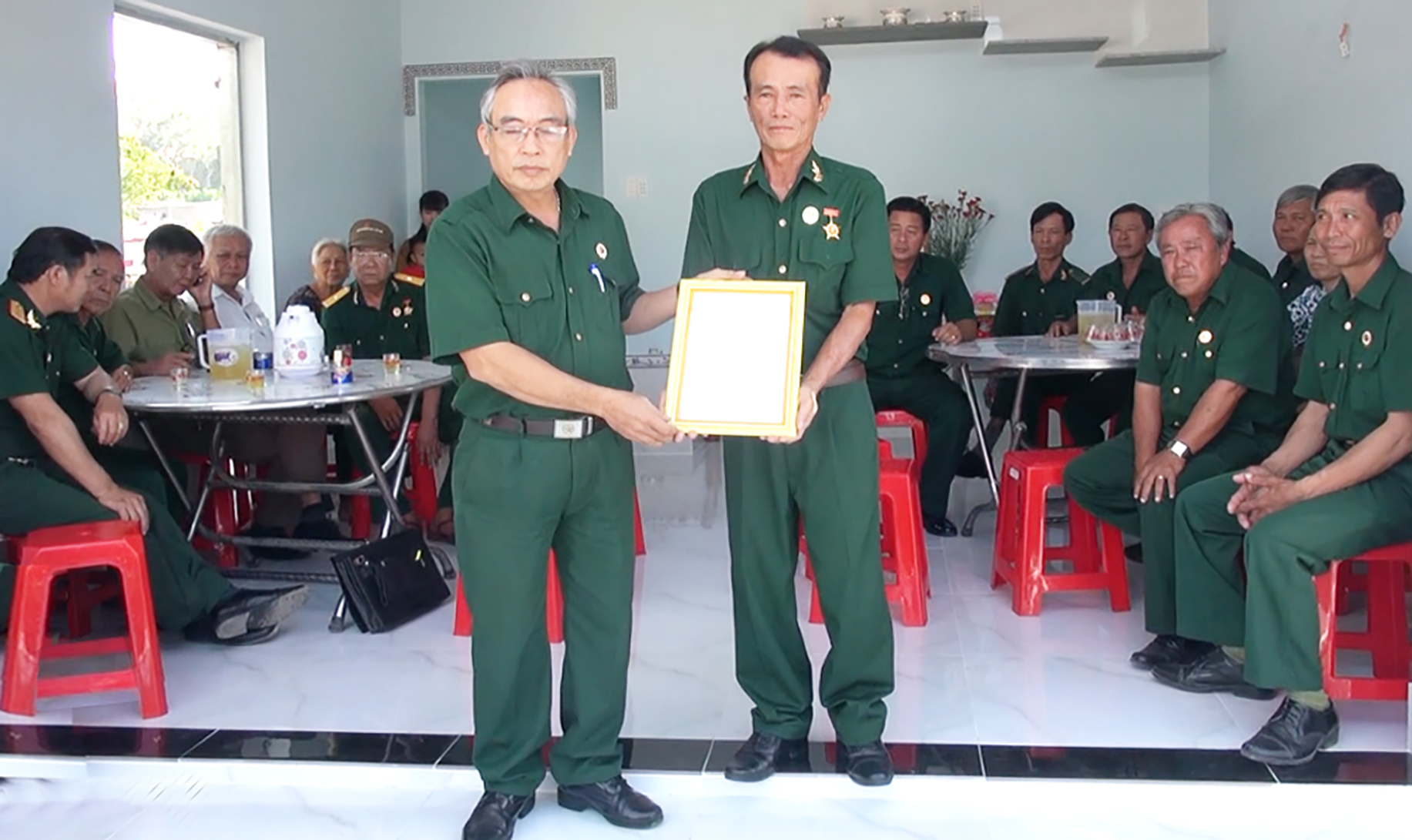 Ông Nguyễn Quang Dương (bên trái), Phó Chủ tịch Hội CCB huyện Long Điền trao Quyết định bàn giao nhà “Nghĩa tình đồng đội” cho CCB Đặng Văn Phước.
