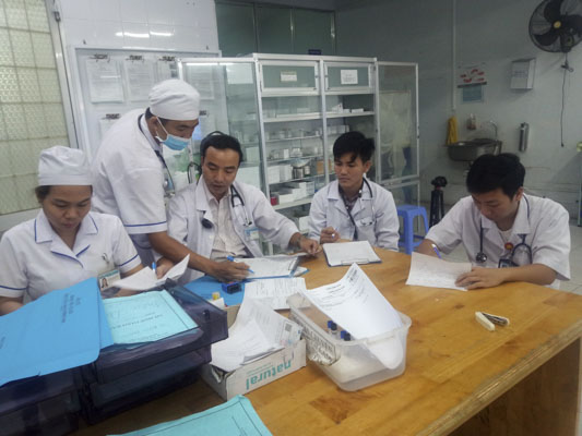 Hai bác sĩ trẻ (góc phải) hỗ trợ bác sĩ trực làm hồ sơ bệnh án cho bệnh nhân tại Phòng Cấp cứu, BV Lê Lợi. Ảnh: MINH THIÊN