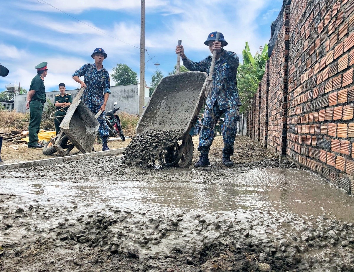 Cán bộ, chiến sĩ đổ bê tông làm đường giao thông tại khu vực Giáo xứ Phước Lộc (khu phố Tân Lộc, phường Phước Hòa).