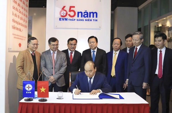 Thủ tướng Nguyễn Xuân Phúc lưu bút tại Phòng truyền thống của Tập đoàn Điện lực  Việt Nam. Ảnh: THỐNG NHẤT 
