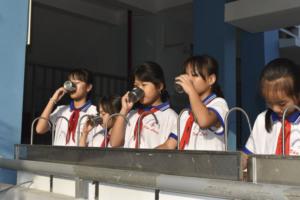 Học sinh Trường TH Văn Lang (TX. Phú Mỹ) uống nước từ máy lọc nước sạch do Công ty Dầu khí  Rosneft Việt Nam trao tặng.