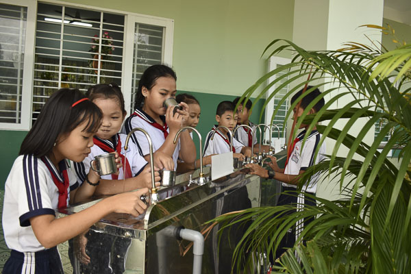 Học sinh Trường TH Long Sơn I (xã Long Sơn, TP. Vũng Tàu) uống nước từ máy lọc nước do Công ty Samsung Engineering tài trợ.