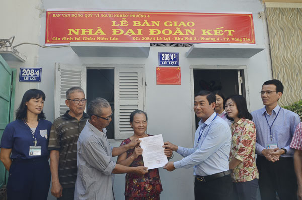 Ông Đinh Quang Định, Chủ tịch UBMTTQ Việt Nam phường 4  trao Quyết định bàn giao nhà cho hộ gia đình bà Châu Niên Lúc.
