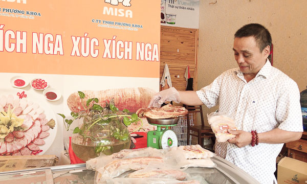 Ông Nguyễn Thanh Phương, Giám đốc Công ty TNHH Phương Khoa (thương hiệu Misa) cân xúc xích xông khói, ba rọi xông khói kiểu Nga chuẩn bị giao cho khách. Ảnh: QUANG VŨ