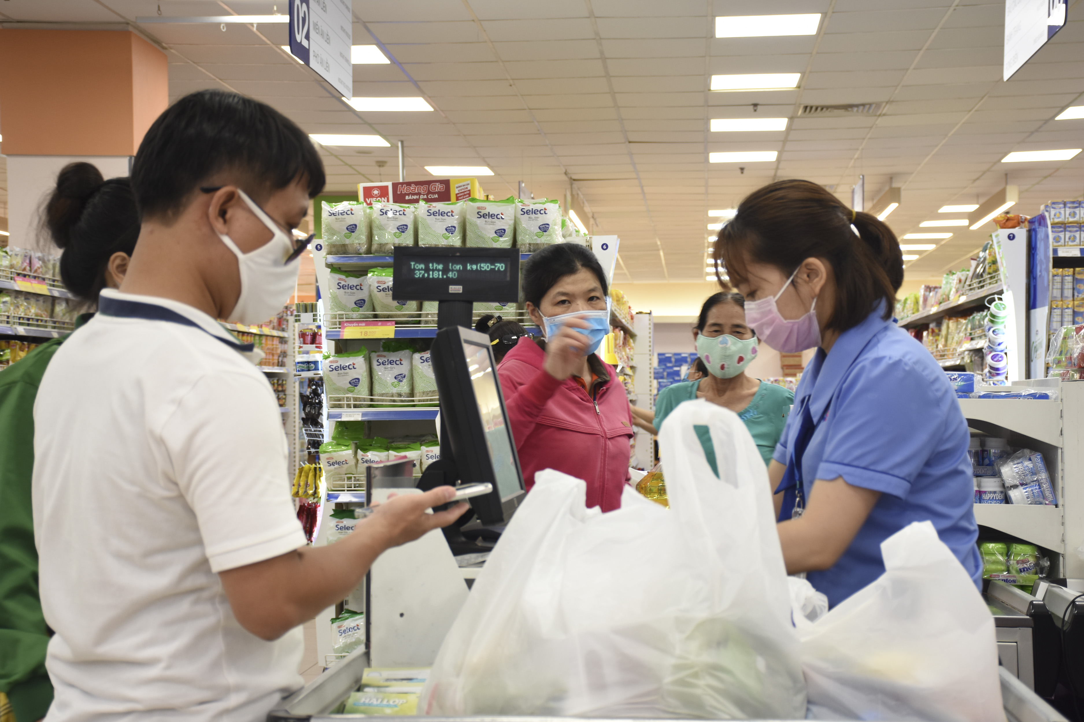 Nhân viên và khách hàng đeo khẩu trang để phòng, chống dịch COVID-19 tại siêu thị Co.op Mart.