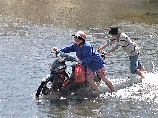 Mặc dù chưa phải mùa mưa, mực nước sông chừng 30cm, nhưng người dân đã phải đẩy xe qua vì chết máy.