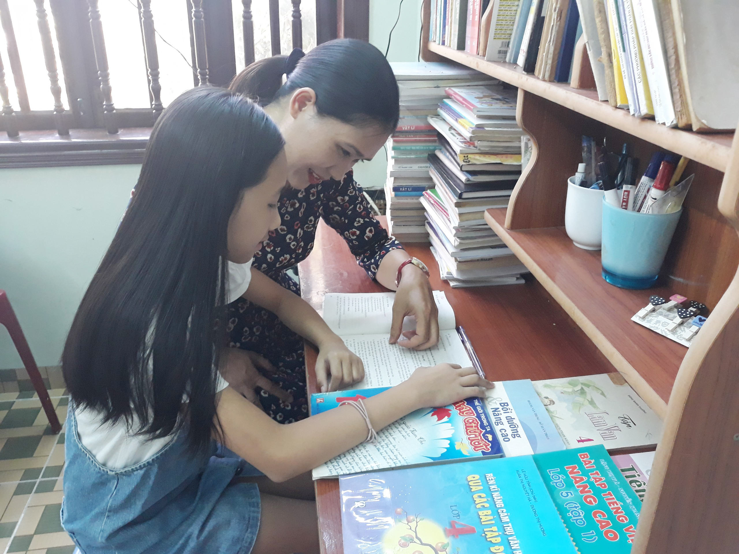 Bà Trần Thị Phúc, mẹ bé Hoài An hướng dẫn con học bài.