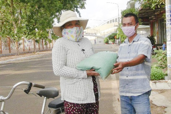 Anh Huỳnh Văn Trung tặng gạo cho bà Lê Thị Năng, người làm thuê cho một cơ sở kinh doanh ăn uống trên địa bàn TT. Ngãi Giao.