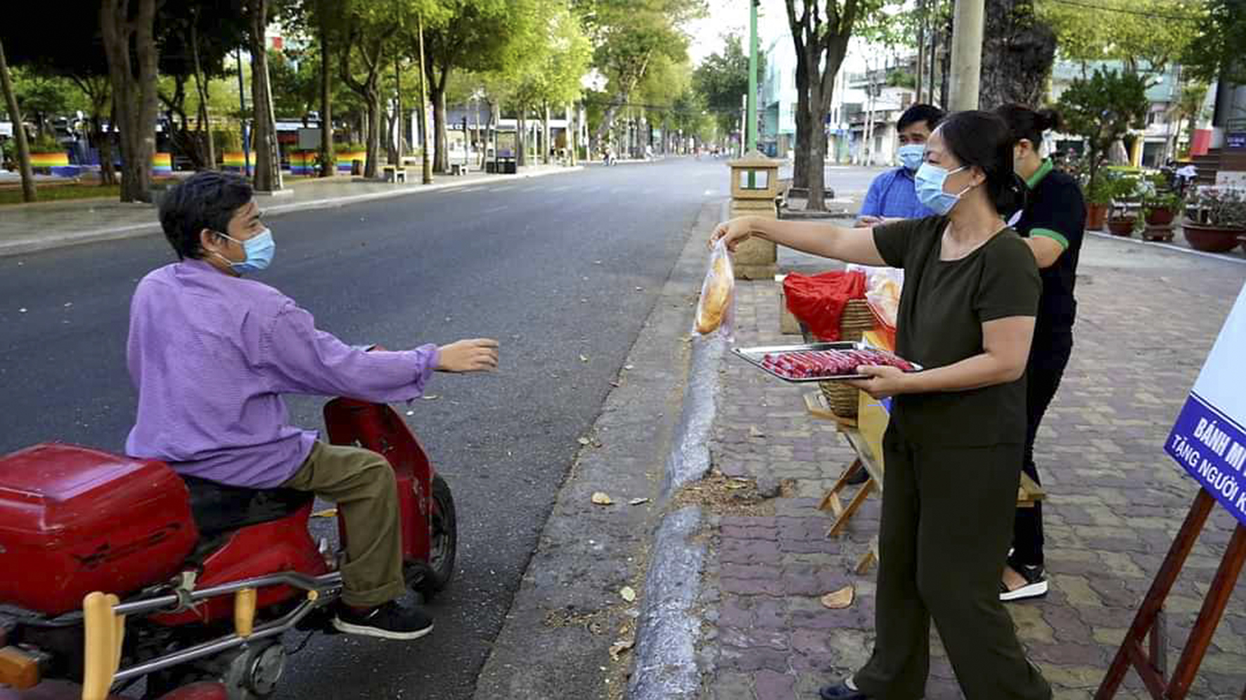 Người khuyết tật nhận bánh mì kẹp xúc xích tại Cafe Chiêng (số 2 Trưng Trắc, Phường 1, TP. Vũng Tàu). Ảnh: ĐÌNH NAM