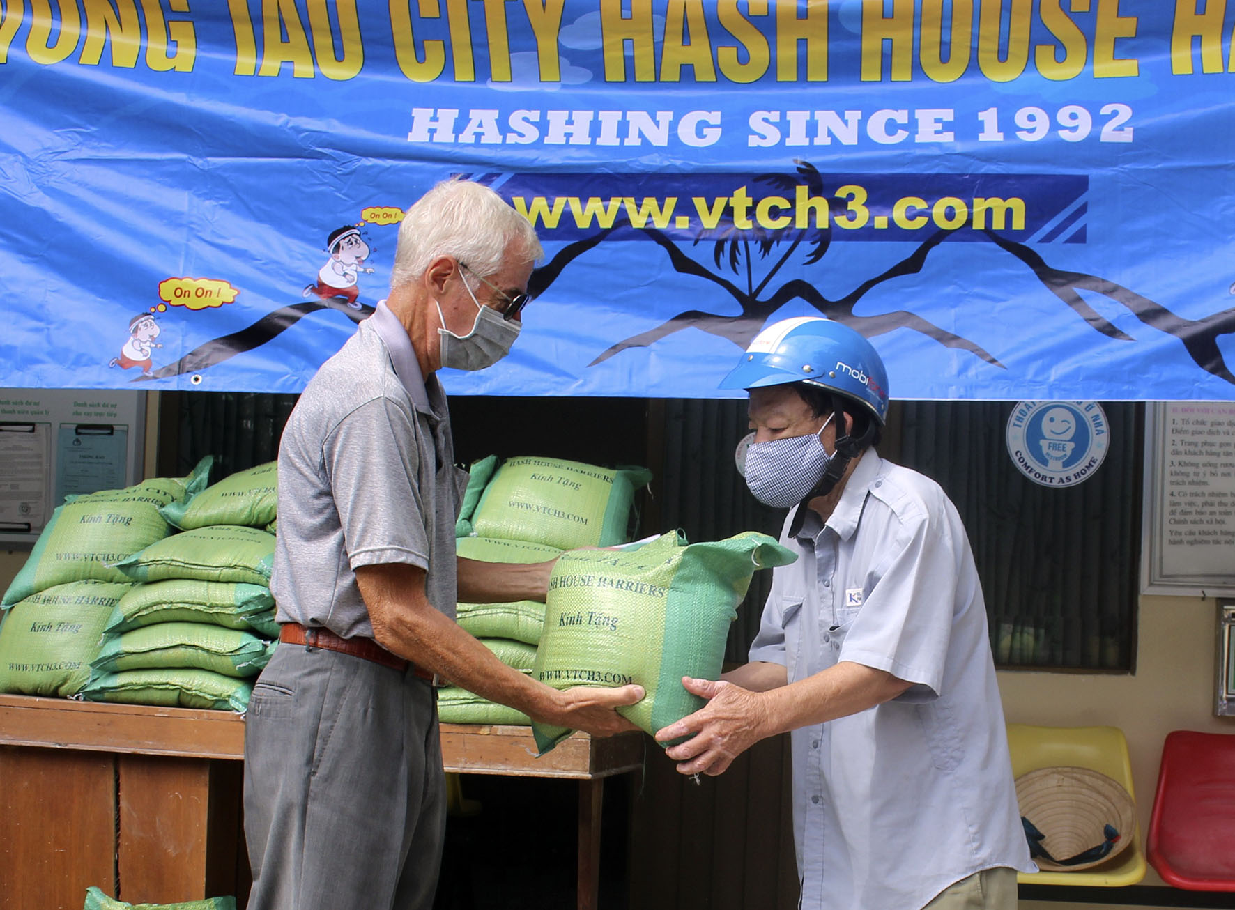 Đại diện nhóm Vung Tau City Hash House Harriers (bên trái) trao quà cho người nghèo.