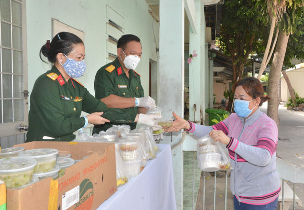 Cán bộ, chiến sĩ Bộ CHQS tỉnh phát cơm tặng bệnh nhân tại BV Lê Lợi. Ảnh: CẨM NHUNG